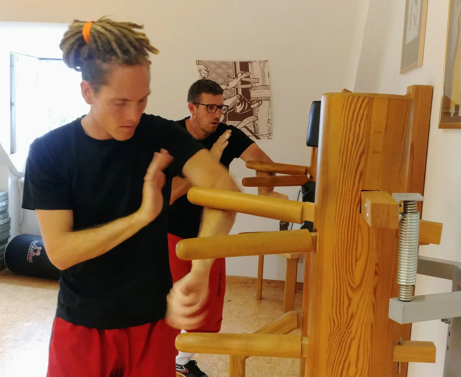 Erwachsene trainieren an der Wing-Chun-Holzpuppe