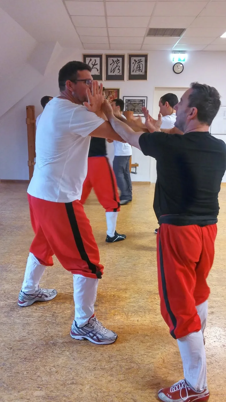 Zwei Erwachsene üben einen kontrollierten Wing-Chun-Partnerkontakt